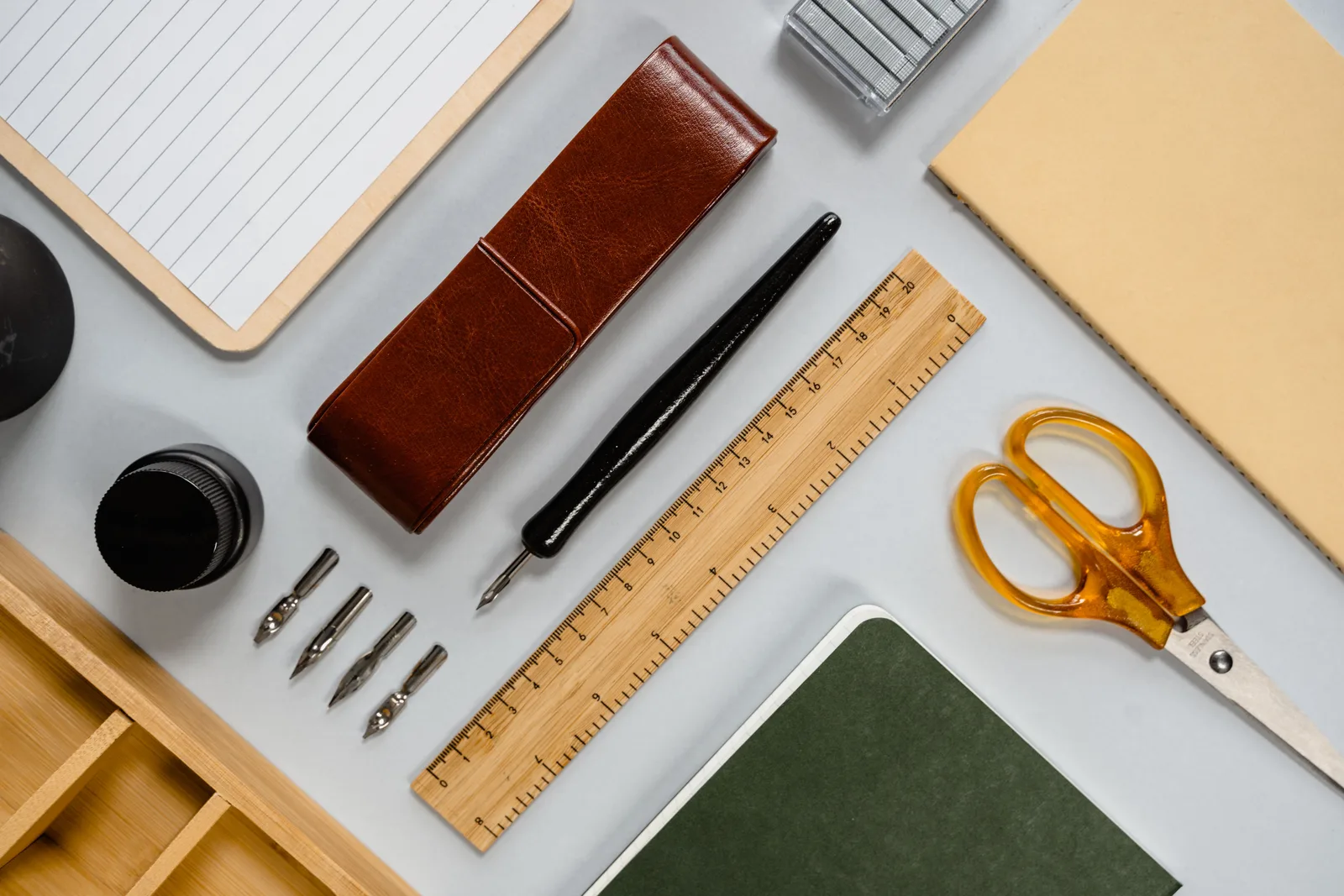 Flat lay of stylish desk stationery including pens, notebooks, and tools. Paper craft case studies mistakes: 4 errors reading guides