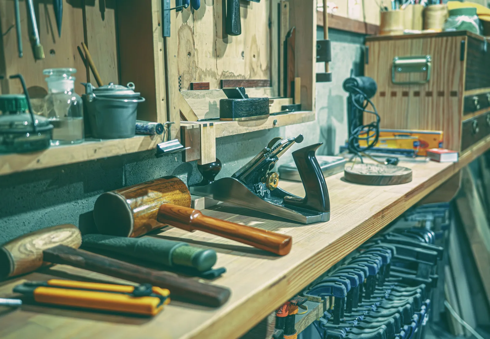 A tidy workshop bench with various woodworking tools and clamps neatly arranged. Archival standards for handmade books at the bench