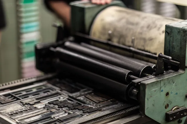 Detailed view of an industrial printing press with precise mechanics. 3 ways Ontario winters dry paper, and what to change at the press